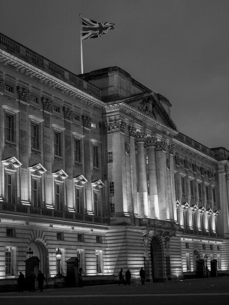 A close-up shot of the UK Parliament building with a financial document overlayed. The lighting is dramatic, emphasizing the importance of governmental financial decisions.
